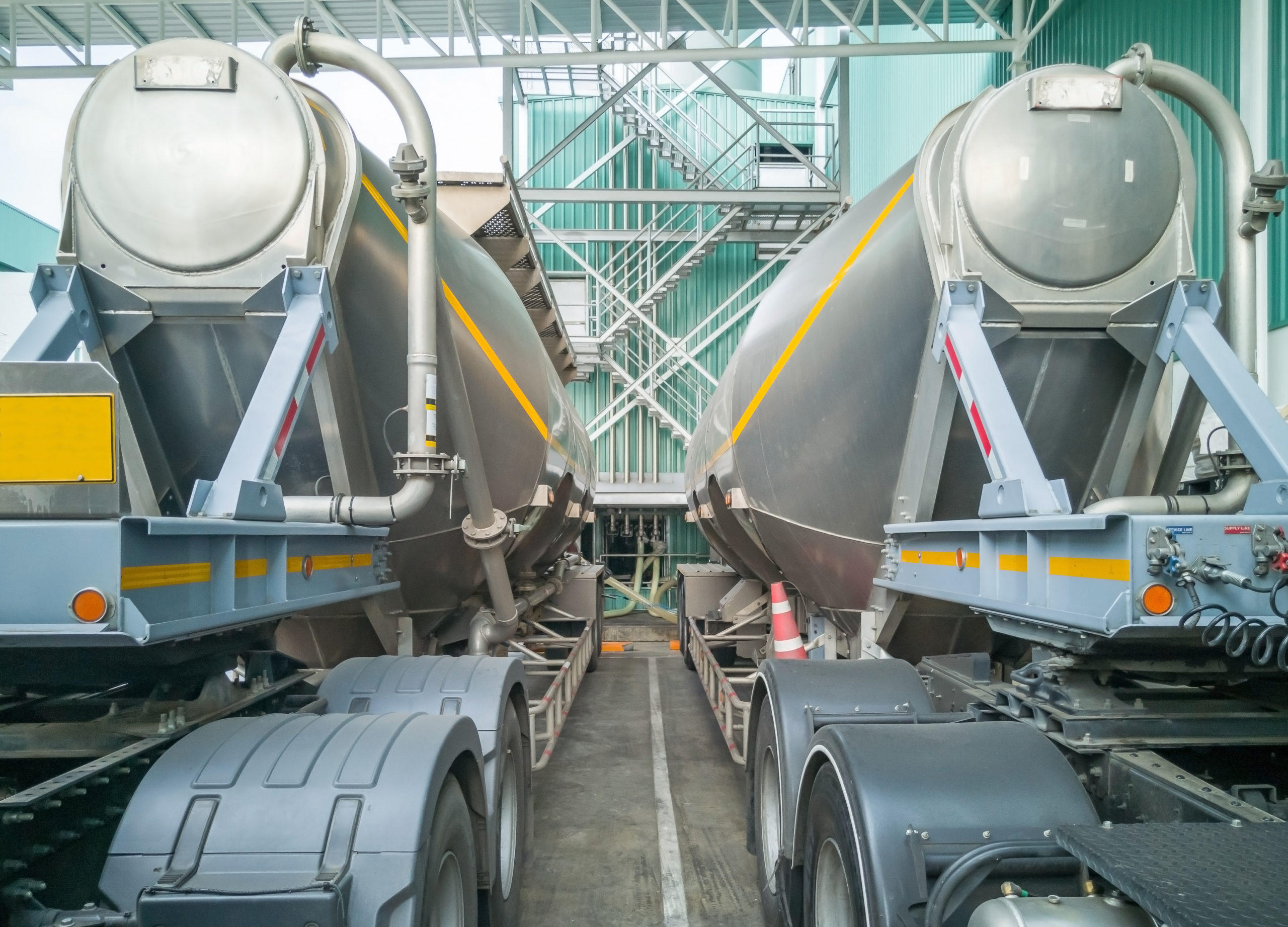 Tanker truck loading sugar into a storage silo at a manufacturing facility