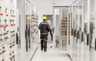 Technicien supervisant les armoires électriques dans un environnement Industrie 4.0 avec solutions de business intelligence