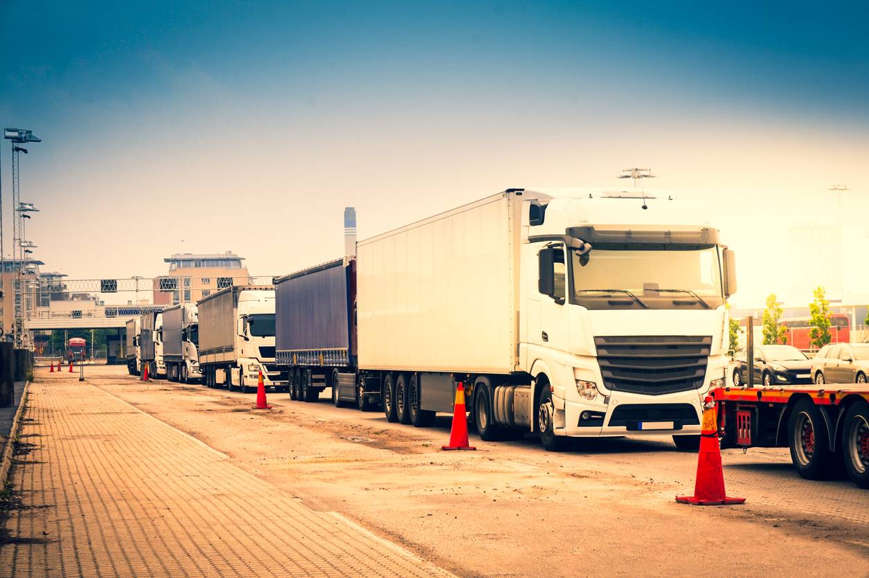 Trucks lined up at a factory entrance illustrating logistics flow management