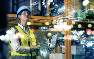 Female operator in protective equipment analyzing digital reports in an industrial setting