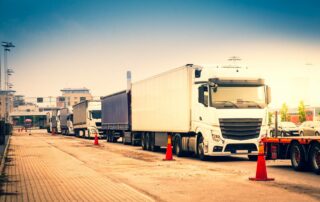 Camions alignés à l’entrée d’usine illustrant la gestion des flux logistiques