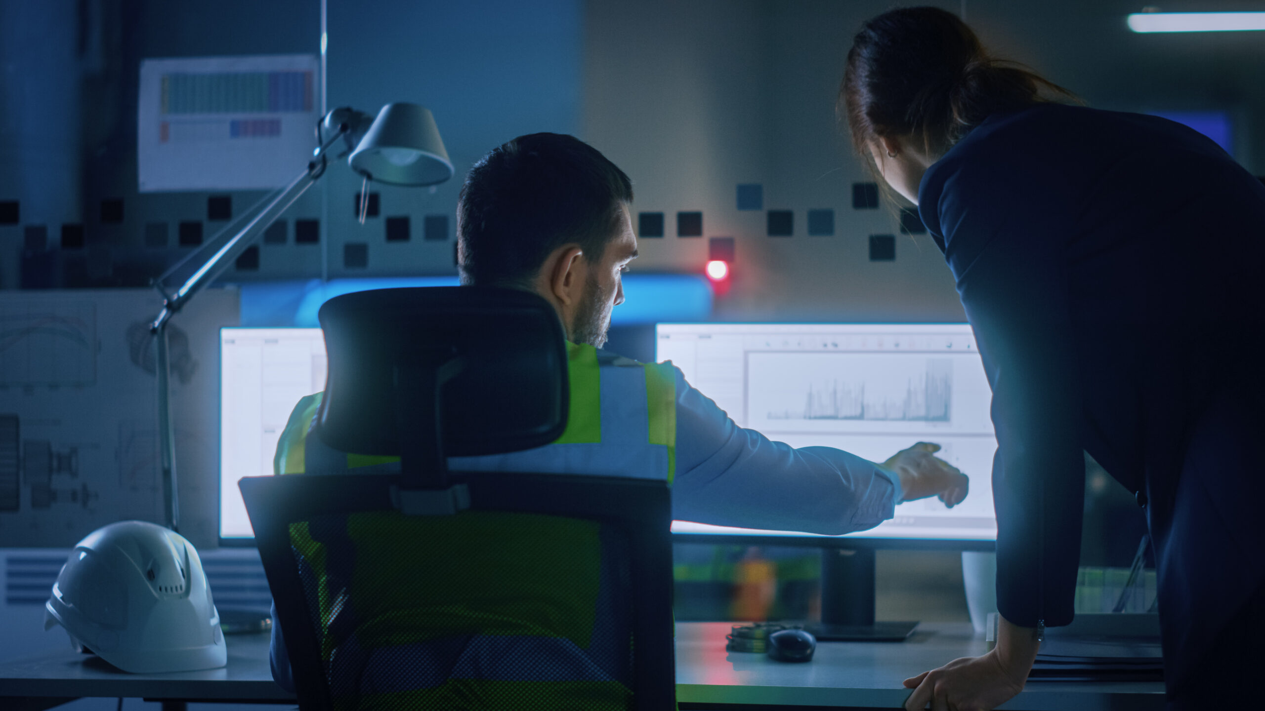 Opérateurs échangeant en consultant les données de production affichées sur un système MES